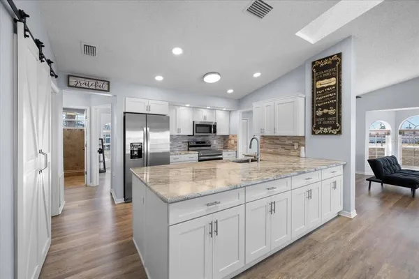 a kitchen with stainless steel appliances granite countertop a sink and cabinets