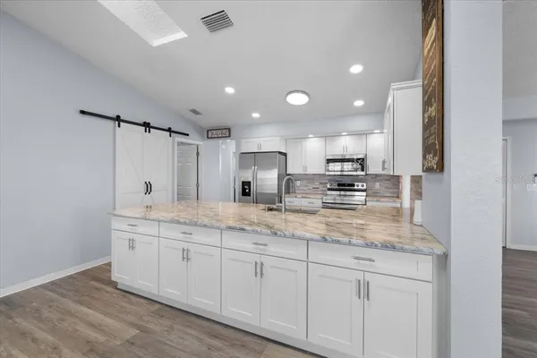 a kitchen with granite countertop a sink and stainless steel appliances