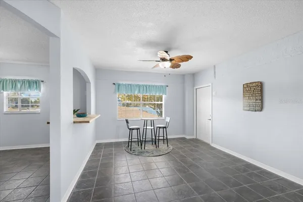 a view of a livingroom with kitchen furniture and floor to ceiling window