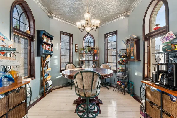 a bedroom with a bed a large window with table and chairs