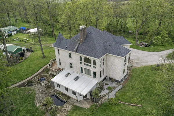 an aerial view of a house with a big yard