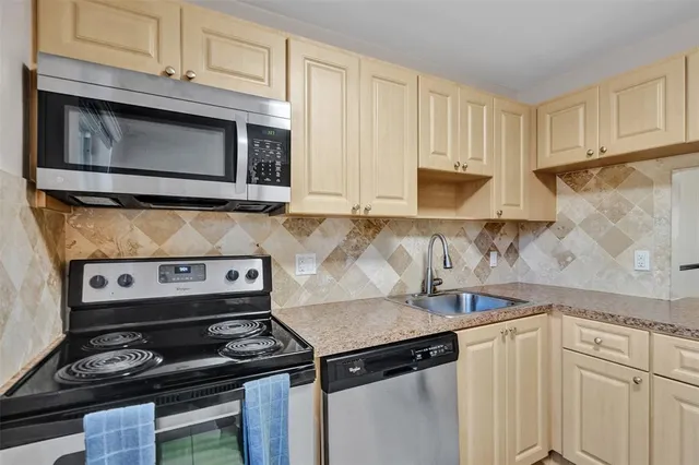 a kitchen with stainless steel appliances granite countertop white cabinets and black stove top oven with granite countertops
