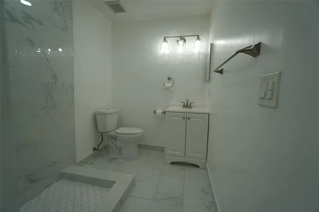 a bathroom with a toilet a sink and mirror