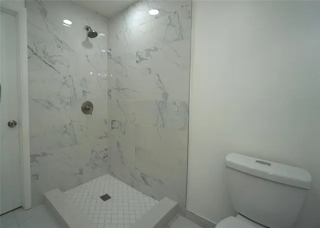 a bathroom with a toilet a sink and mirror