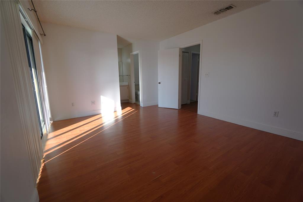 6380 West 24th Court Hialeah, FL 33016 - Photo 31 of 41 an empty room with wooden floor and windows