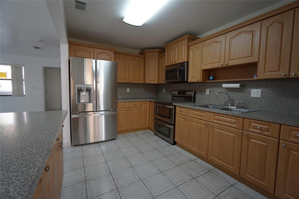 6380 West 24th Court Hialeah, FL 33016 - Photo 9 of 41 a kitchen with stainless steel appliances granite countertop a refrigerator sink and cabinets