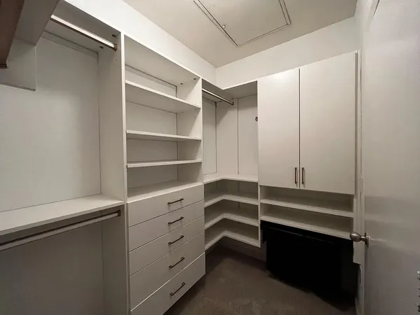 a view of walk in closet with empty racks