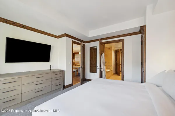a bedroom with a bed and a flat screen tv