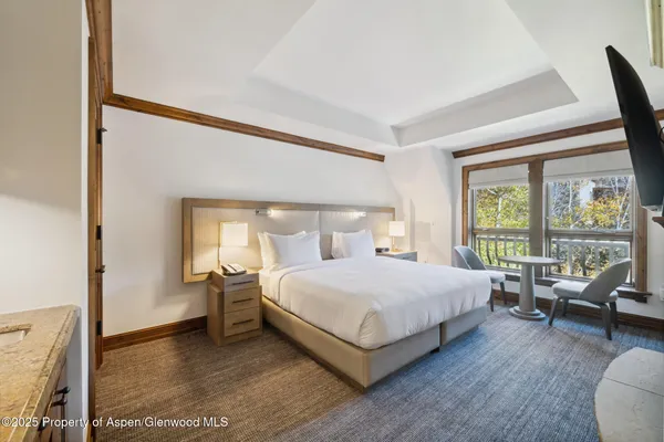 a bedroom with a bed and large window