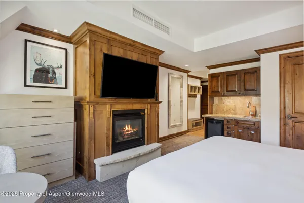 a spacious bedroom with a bed and a flat screen tv
