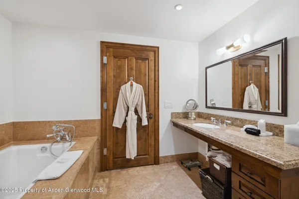 a bathroom with a tub sink and mirror