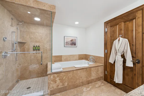a bathroom with a tub a sink and a shower
