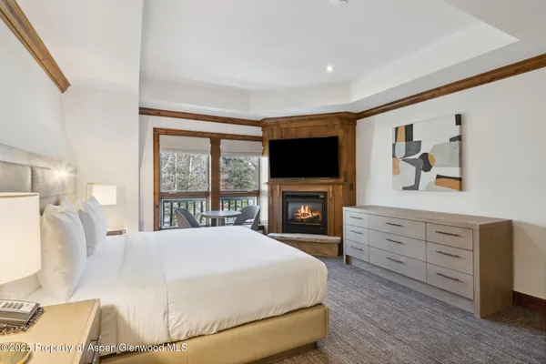a spacious bedroom with a bed and a flat screen tv