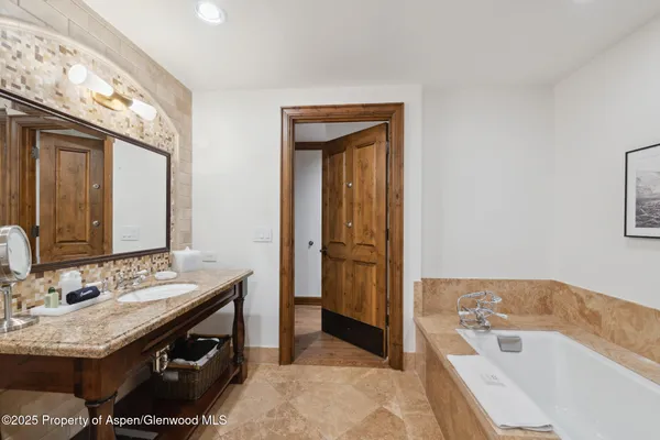 a bathroom with a tub sink and mirror