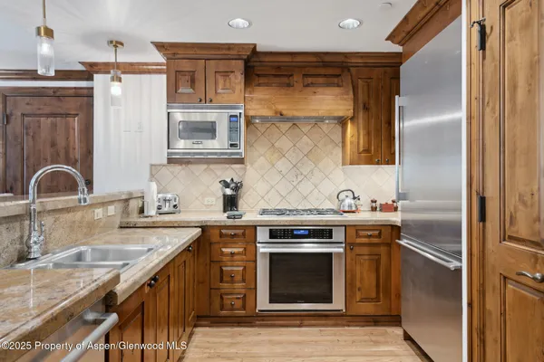 a kitchen with stainless steel appliances granite countertop a sink stove and refrigerator