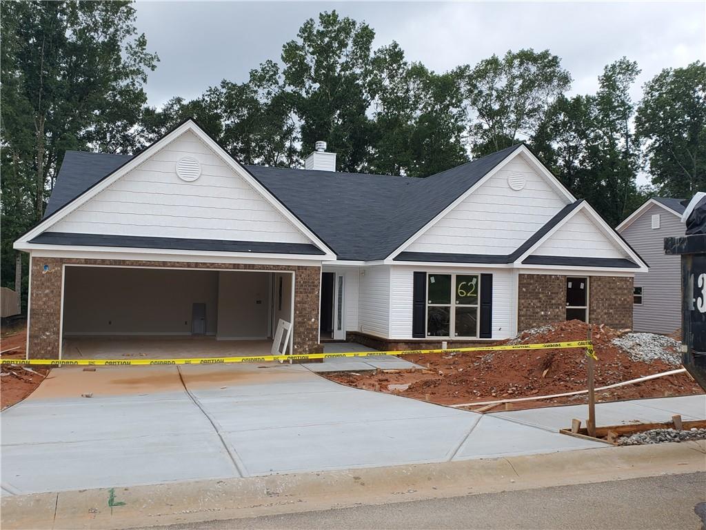 a view of a white house with large windows and a tree with yard in front of it