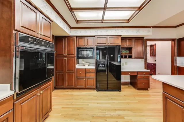 a large kitchen with stainless steel appliances wooden floors and large window
