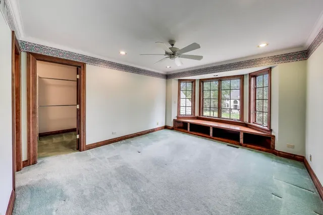 a view of a room with a ceiling fan and window