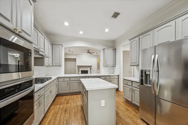 a kitchen with kitchen island a counter top space a stove and refrigerator