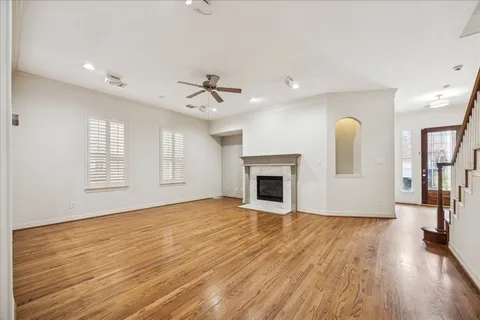 a view of empty room with wooden floor and fireplace