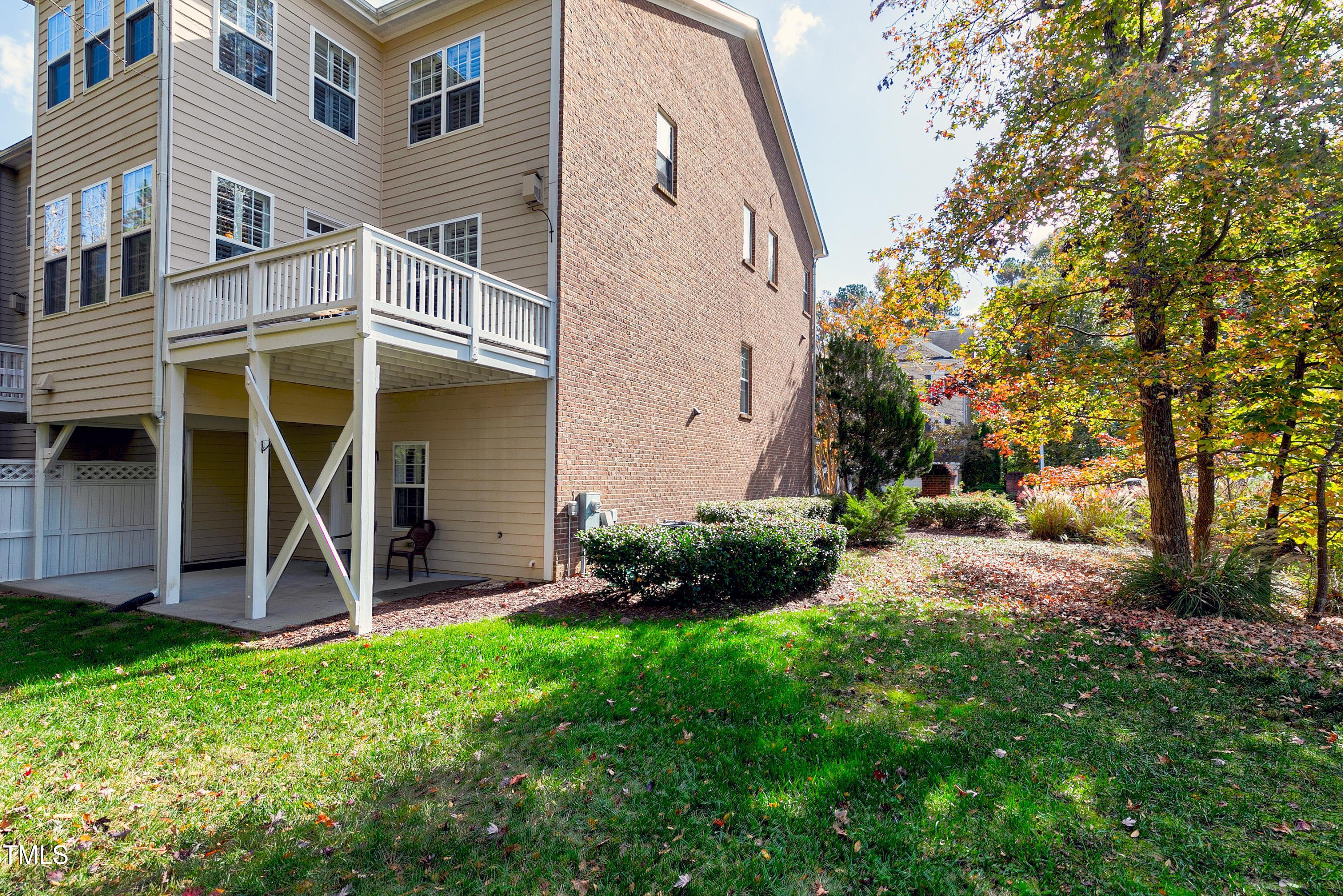 303 Bridgegate Drive Cary, NC 27519 - Photo 13 of 25 a view of a patio with table and chairs and potted plants and large trees
