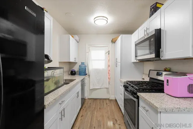 a large kitchen with stainless steel appliances granite countertop a stove a sink and a microwave