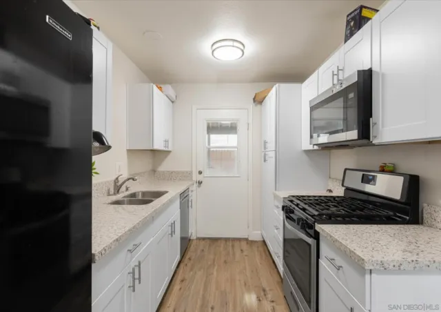 a kitchen with stainless steel appliances granite countertop a stove a sink and a microwave