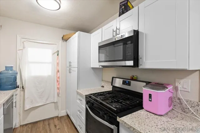 a kitchen with stainless steel appliances a microwave a stove and a microwave