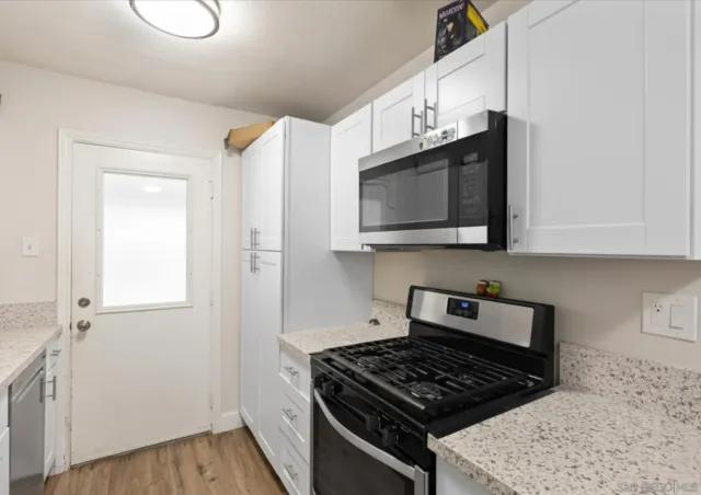 a kitchen with granite countertop a stove and a microwave