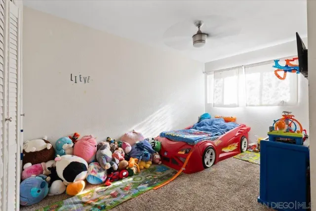 a bedroom with baby bed and a window