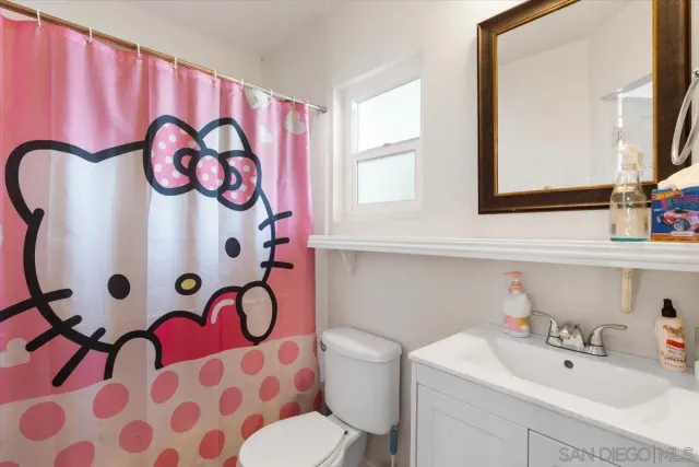 a bathroom with a sink and mirror with toilet