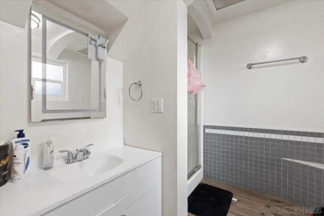 a bathroom with a sink a toilet and shower