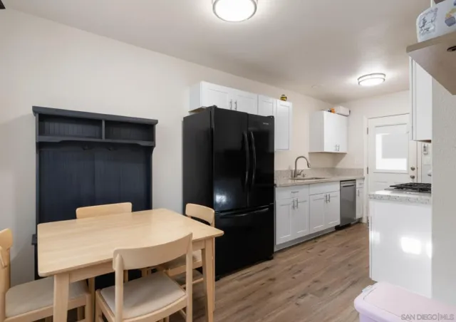 a kitchen with a refrigerator a stove a sink dishwasher with a dining table and chairs