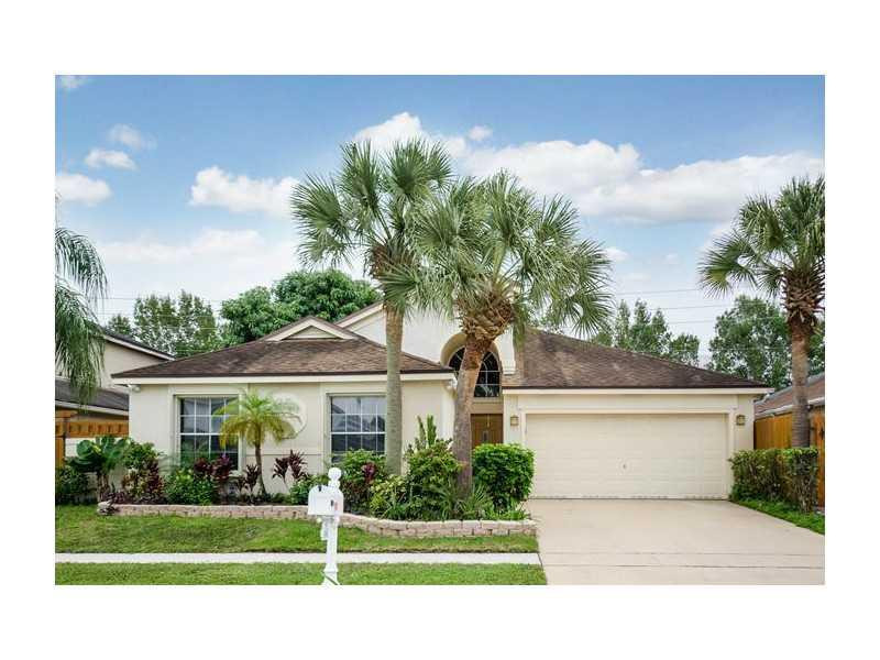 9406 Aegean Drive Boca Raton, FL 33496 - Photo 1 of 17 a front view of a house with a yard and garage