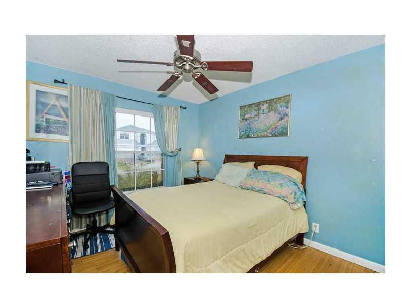 9406 Aegean Drive Boca Raton, FL 33496 - Photo 11 of 17 a bedroom with a bed and a chandelier