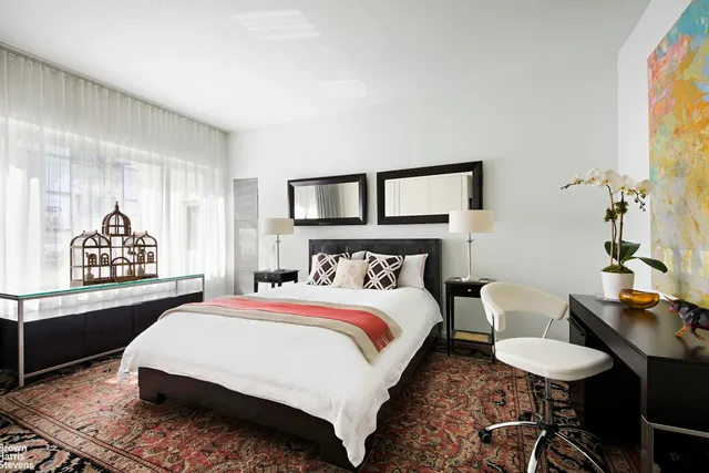 a bedroom with a bed a mirror and a window