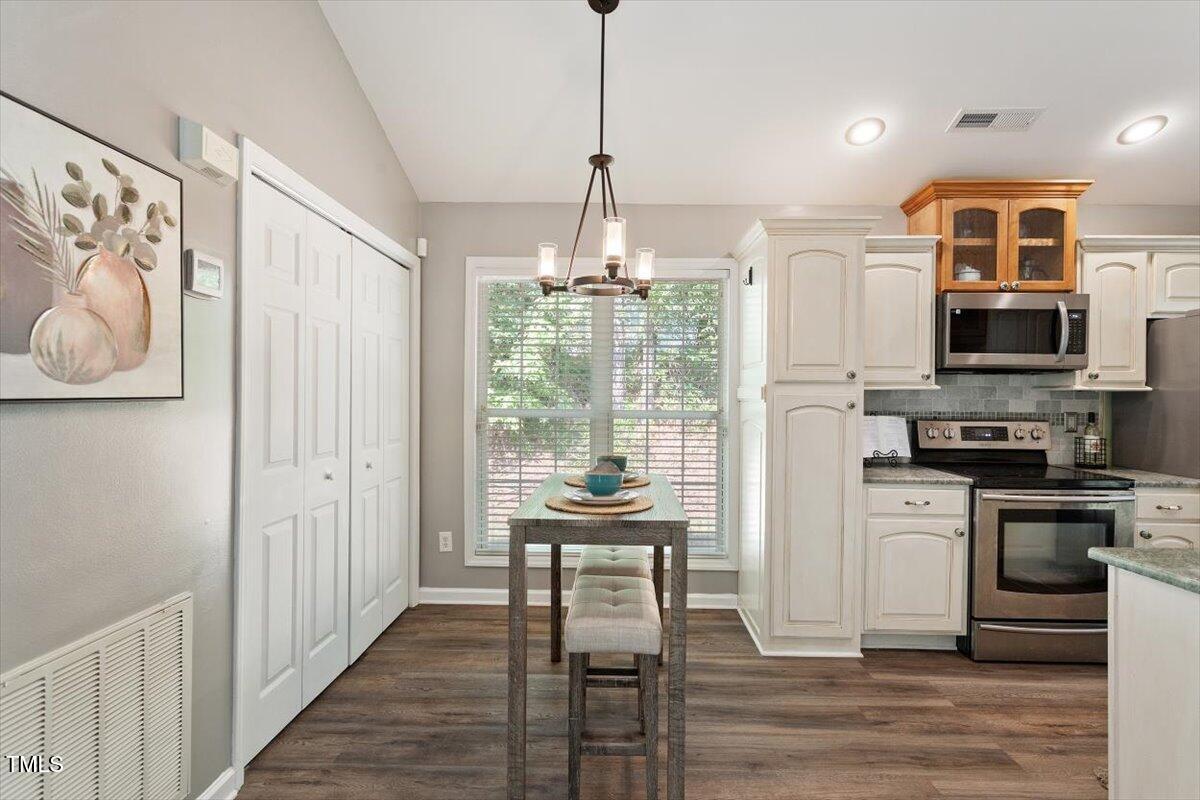 6412 Forest Ridge Drive Durham, NC 27713 - Photo 17 of 32 a dining room with stainless steel appliances granite countertop a refrigerator and a stove top oven