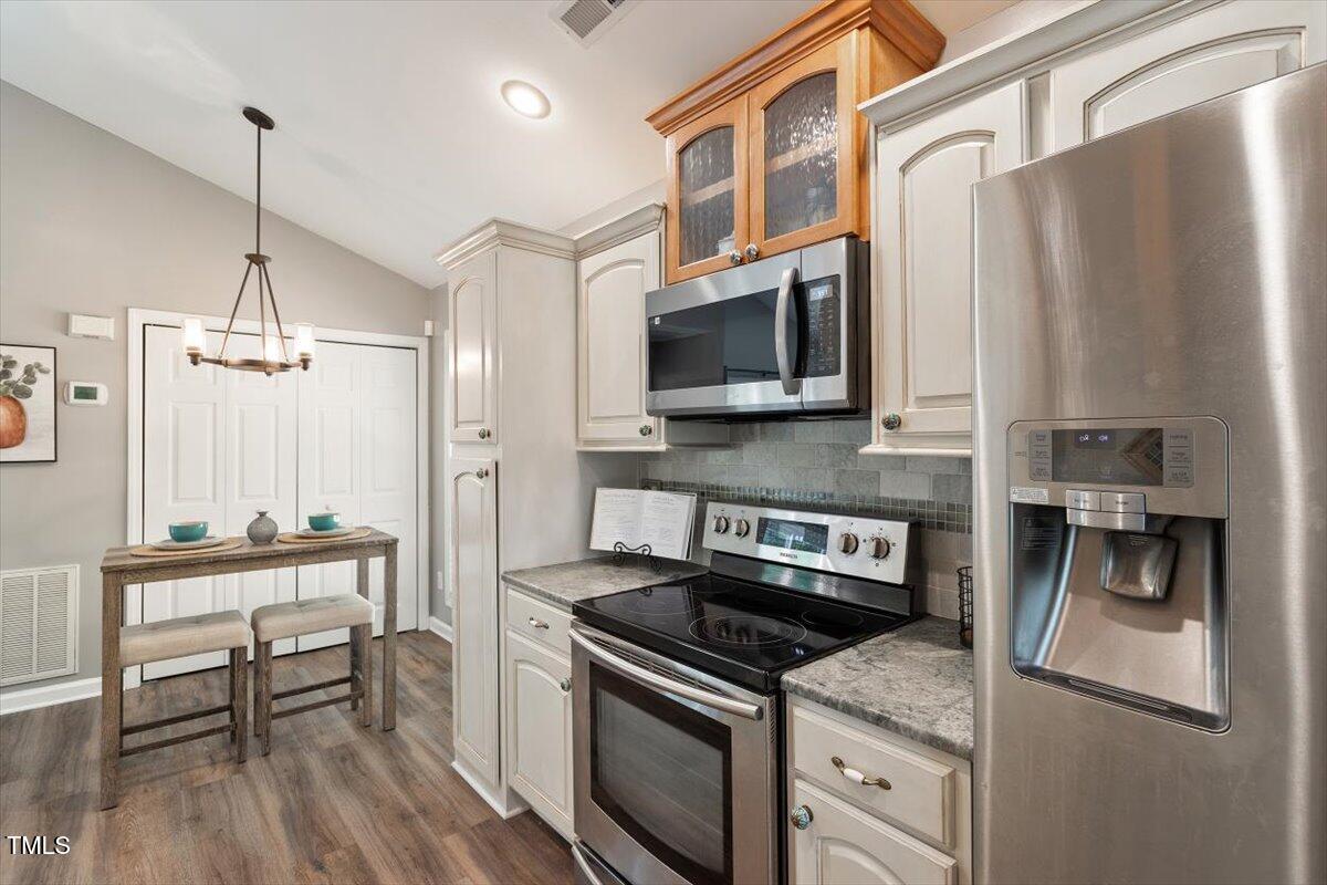 6412 Forest Ridge Drive Durham, NC 27713 - Photo 21 of 32 a kitchen with stainless steel appliances a stove a sink and a refrigerator