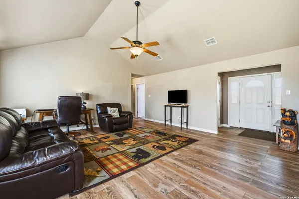 a living room with furniture and a wooden floor