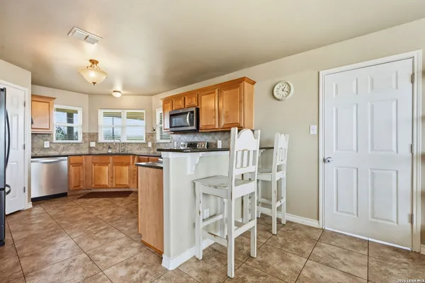 a kitchen with stainless steel appliances granite countertop a refrigerator and a stove