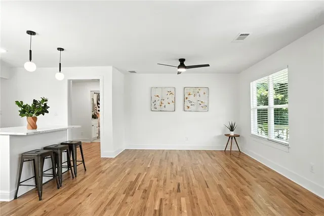 a view of empty room with wooden floor and fan