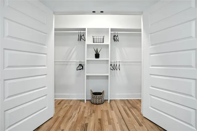 a view of a bedroom with wooden floor and white cabinet