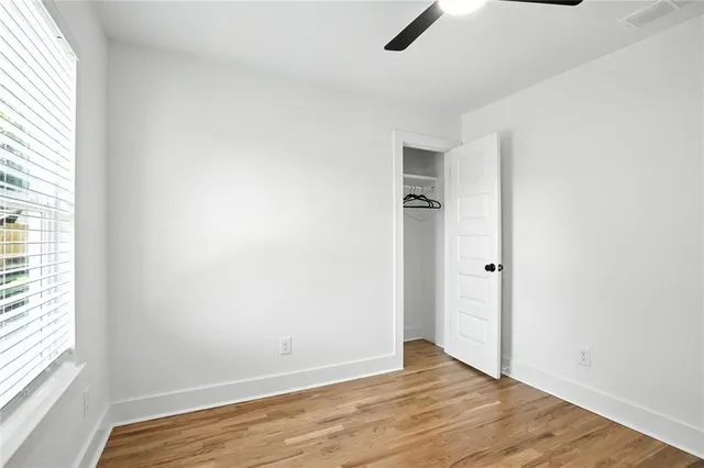 an empty room with closet and windows