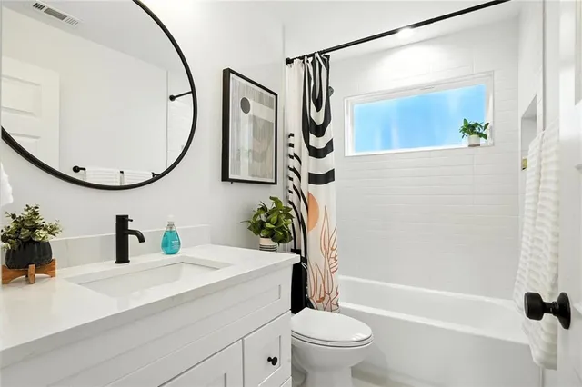 a bathroom with a sink a mirror a bathtub and a toilet