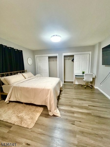 6 Charles Street, Unit 2 Montclair, NJ 07042 - Photo 4 of 13 a bedroom with a bed and wooden floor