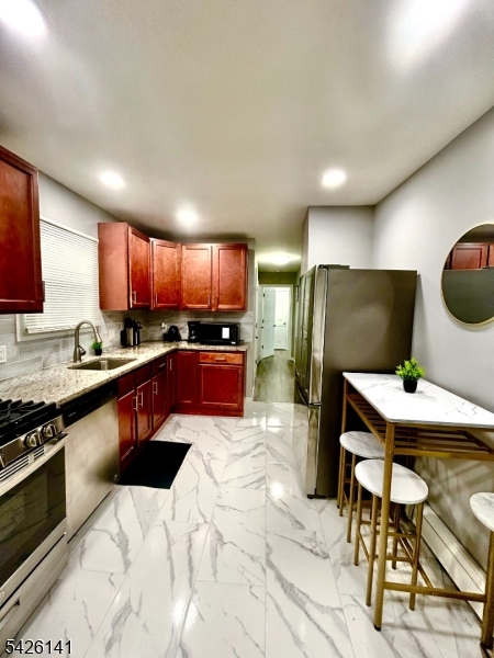 6 Charles Street, Unit 2 Montclair, NJ 07042 - Photo 8 of 13 a kitchen with stainless steel appliances kitchen island granite countertop a sink a stove a refrigerator cabinets and chairs