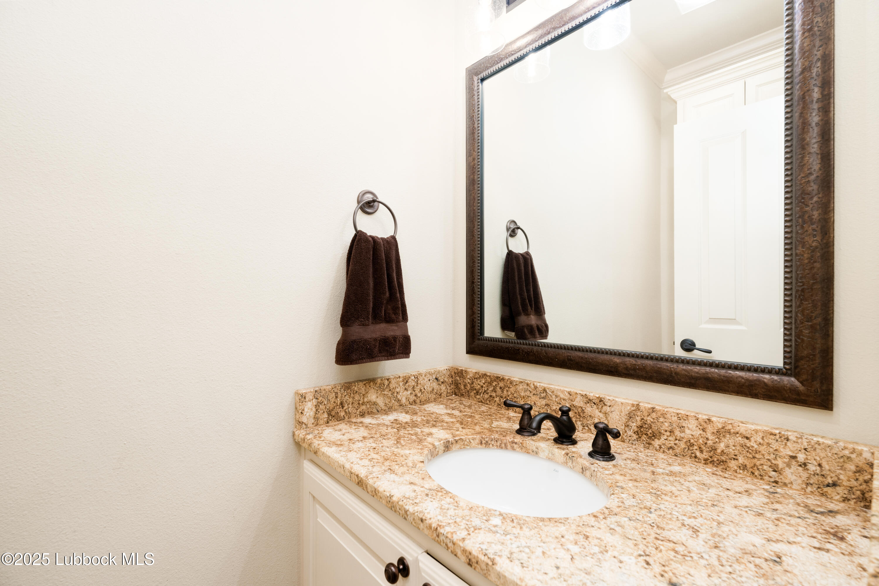 4501 19th Street, Unit 7 Lubbock, TX 79407 - Photo 28 of 30 a bathroom with a granite countertop sink and a mirror