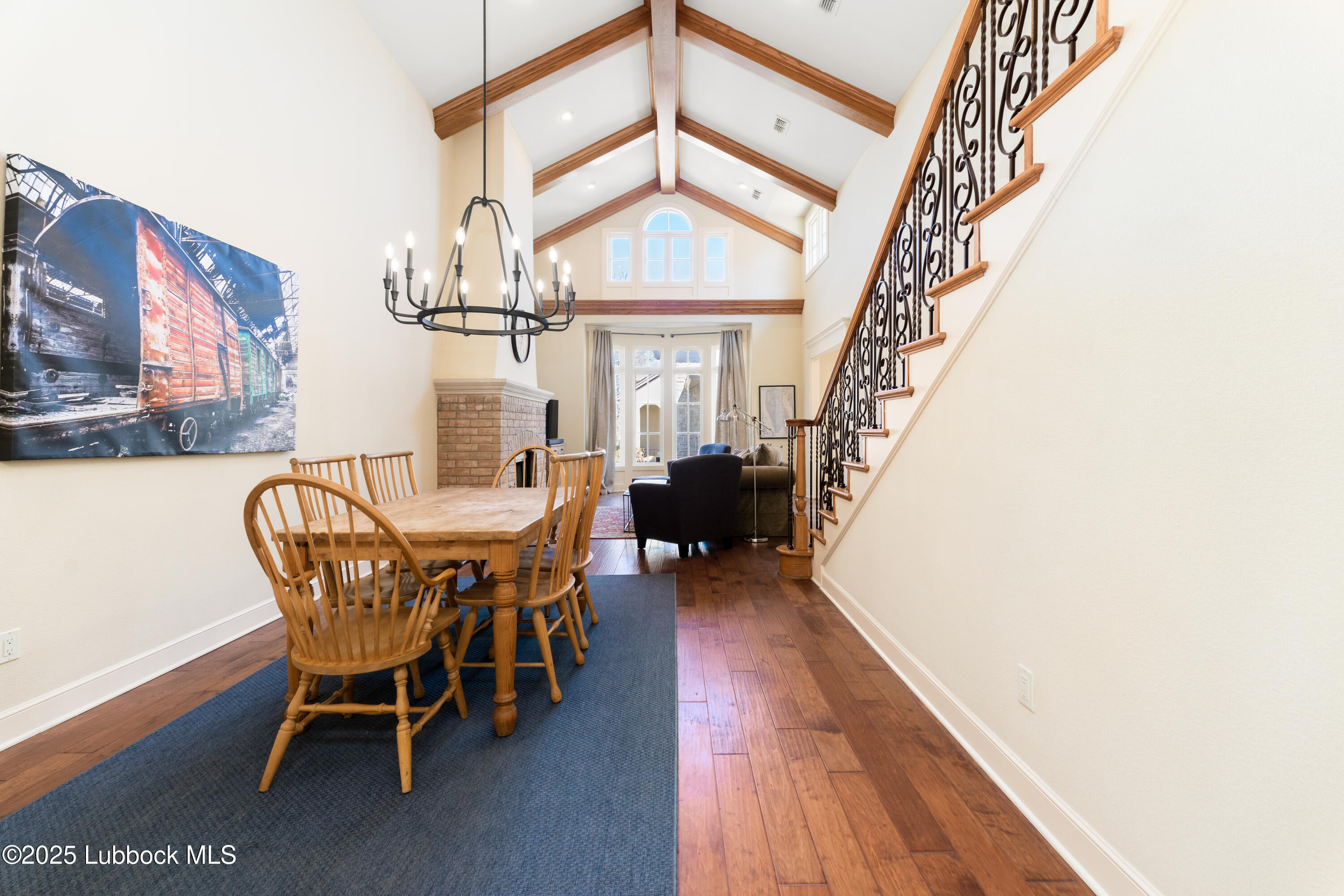 4501 19th Street, Unit 7 Lubbock, TX 79407 - Photo 6 of 30 a dining room with wooden floor a chandelier a wooden table and chairs