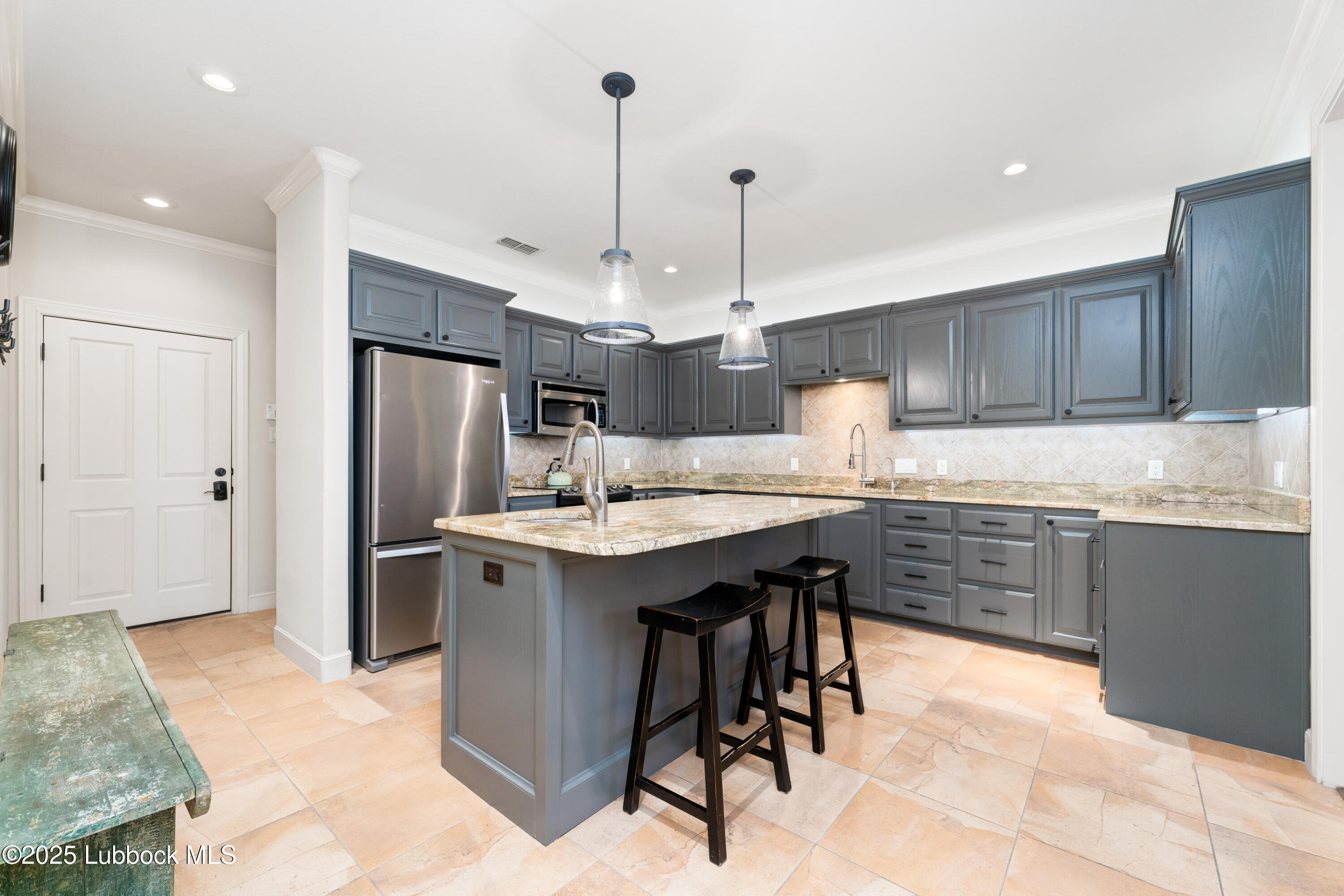 4501 19th Street, Unit 7 Lubbock, TX 79407 - Photo 9 of 30 a kitchen with kitchen island granite countertop a sink a center island and stainless steel appliances