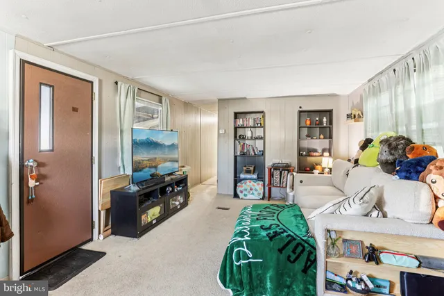 a living room with furniture a clock and a flat screen tv